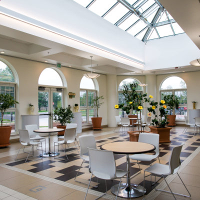 An open, light-filled space filled with tables and fragrant fruit trees.