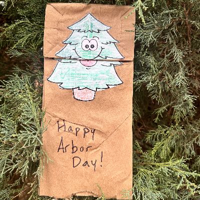 Paper bag green tree puppet among trees