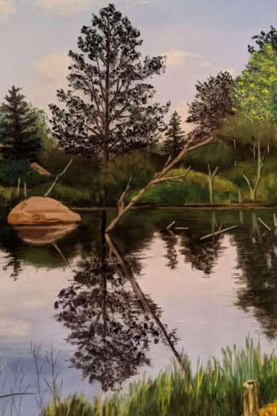 Landscape painting of a calm pond surrounded by trees and large rocks, with reflections mirrored in the still water. A fallen tree extends across the pond, while tall grasses line the foreground under a soft, cloudy sky.